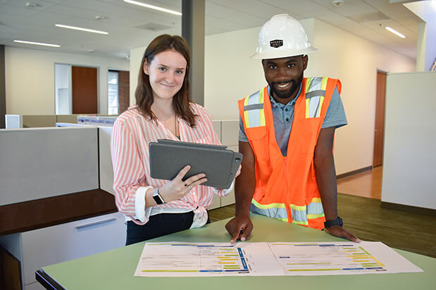A worker helps guide a machine into place.