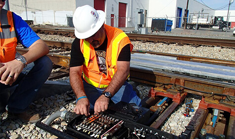 A worker testing an electrical panel.